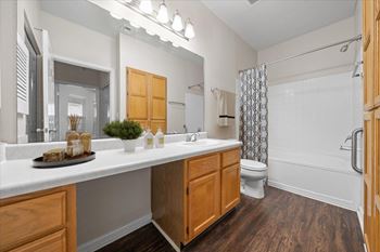 A bathroom with a white countertop and wooden cabinets. at Somerset Oaks Apartment Homes, Olathe, Kansas